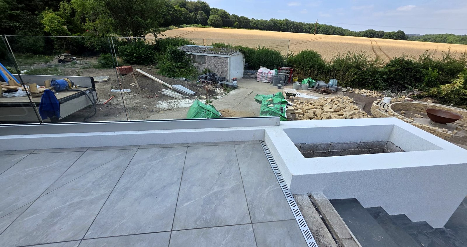 Frameless glass balustrade around a raised patio terrace overlooking fields, Wombwell, Barnsley